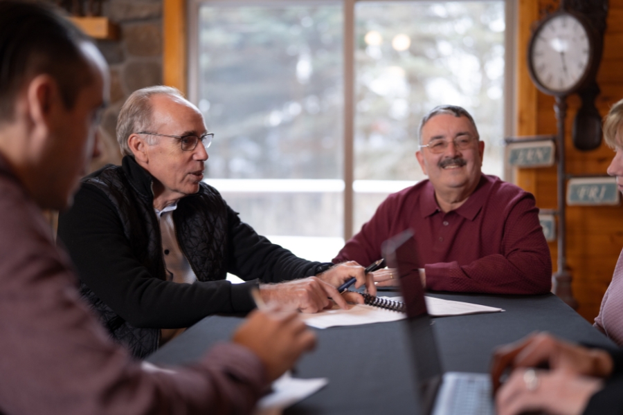 Edward Curley sits around the table in his offices with a couple of happy clients on a snowy day in Oneonta